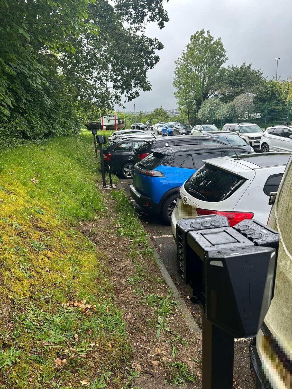 EV chargers lining the staff car park, looking towards the playing fields